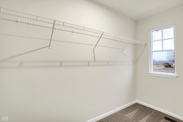 walk in closet featuring dark colored carpet and visible vents