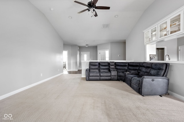 living room with light colored carpet, visible vents, a ceiling fan, vaulted ceiling, and baseboards