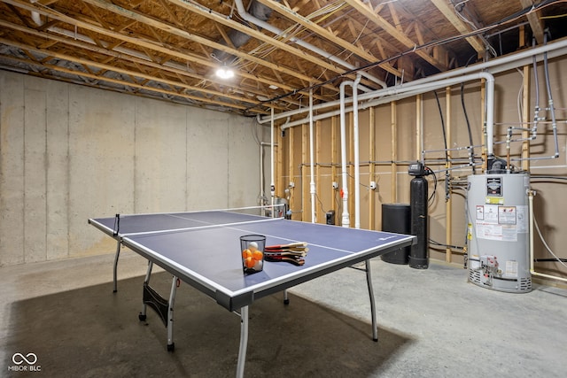 playroom featuring gas water heater and unfinished concrete flooring