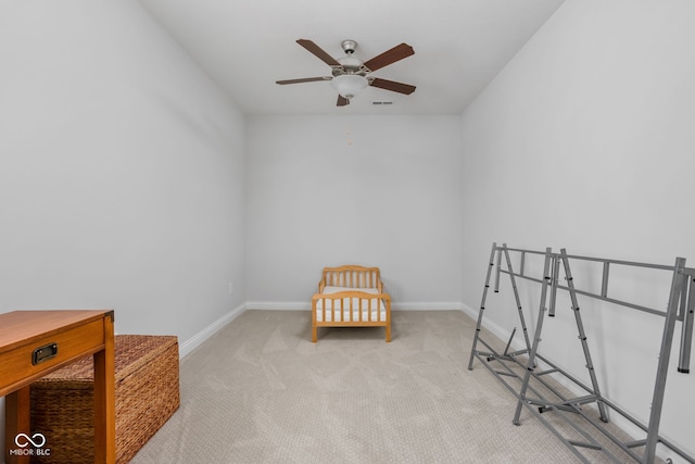 sitting room featuring baseboards, visible vents, a ceiling fan, and light colored carpet