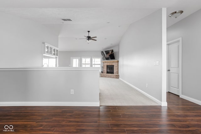 unfurnished living room featuring ceiling fan, a fireplace, visible vents, and baseboards