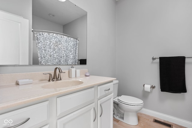 bathroom with baseboards, visible vents, toilet, wood finished floors, and vanity