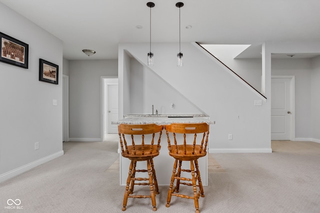 dining area with baseboards, indoor bar, and light colored carpet