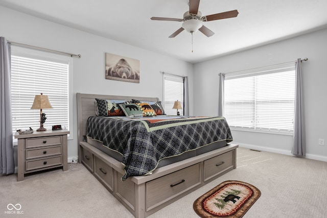 bedroom with light carpet, visible vents, baseboards, and ceiling fan