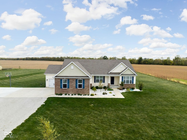 view of front of property with concrete driveway, a rural view, brick siding, and a front lawn