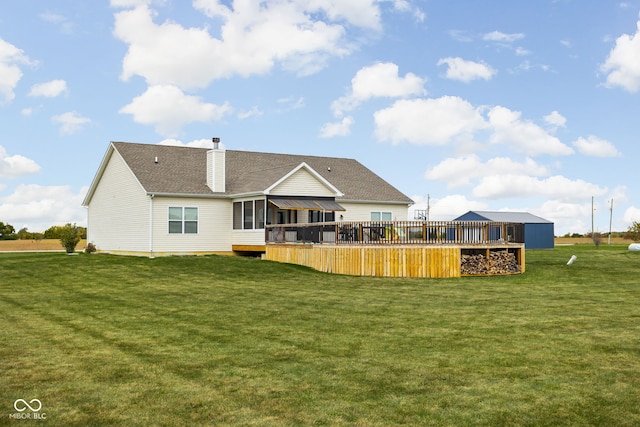 rear view of house with a wooden deck, a chimney, and a yard