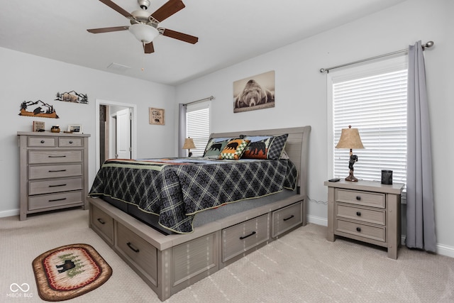 bedroom featuring a ceiling fan, light colored carpet, and baseboards