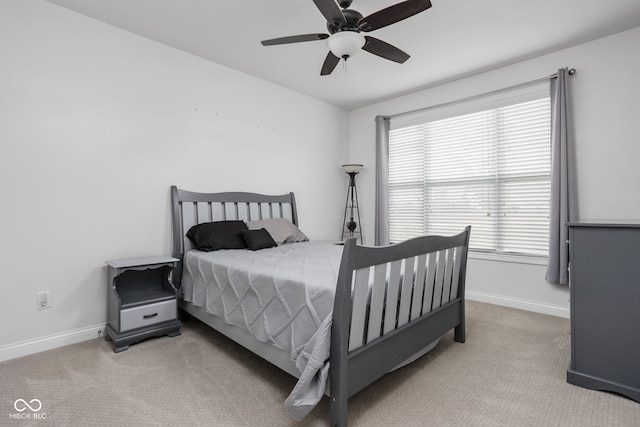 bedroom with light carpet, baseboards, and a ceiling fan