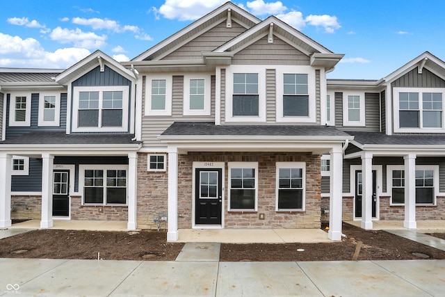 view of front of home with a porch, stone siding, and board and batten siding