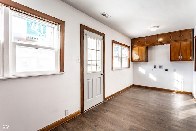 interior space with dark wood finished floors, visible vents, and baseboards