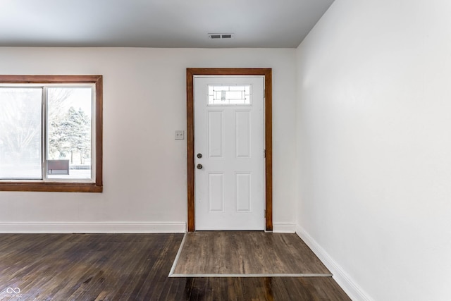 foyer featuring baseboards, wood finished floors, and visible vents