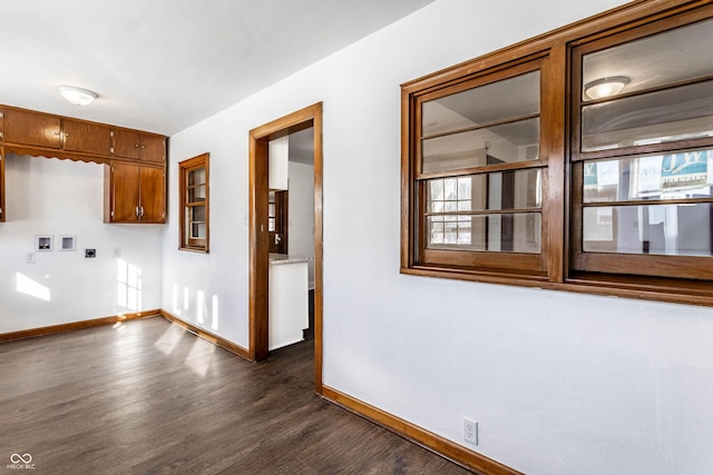 interior space featuring baseboards and dark wood-style floors