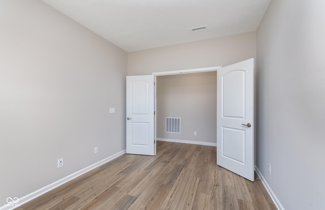 unfurnished bedroom featuring light wood finished floors, baseboards, and visible vents