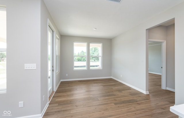 unfurnished room featuring baseboards, visible vents, and light wood finished floors