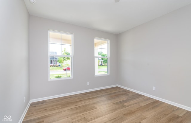 empty room with light wood finished floors and baseboards