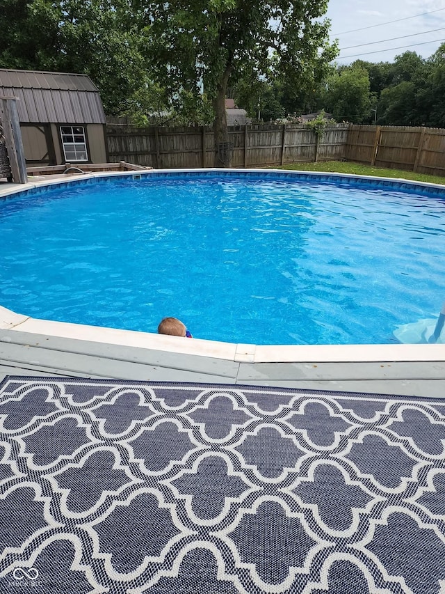 view of pool with a fenced backyard, a fenced in pool, and an outdoor structure