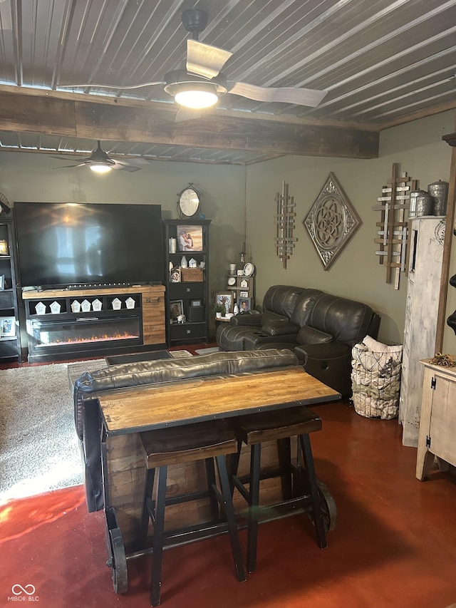 living room featuring a glass covered fireplace and finished concrete floors