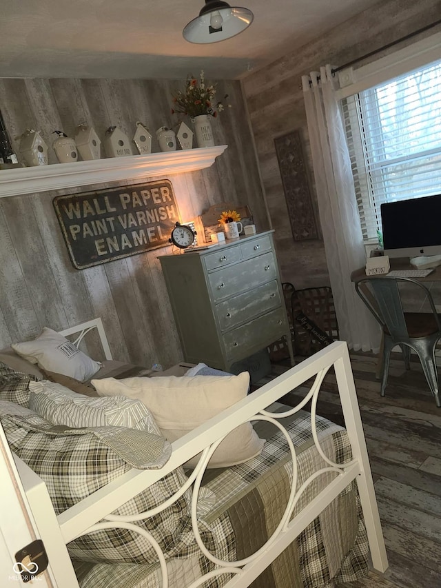 bedroom featuring wood finished floors and wooden walls