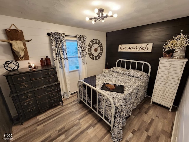 bedroom featuring a chandelier and wood finished floors