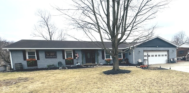 ranch-style house featuring a front yard, concrete driveway, brick siding, and an attached garage