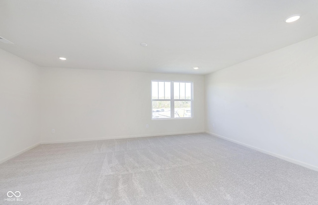 unfurnished room featuring recessed lighting, light colored carpet, and baseboards