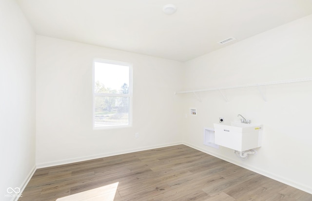 laundry room featuring hookup for a washing machine, visible vents, light wood-style floors, laundry area, and baseboards