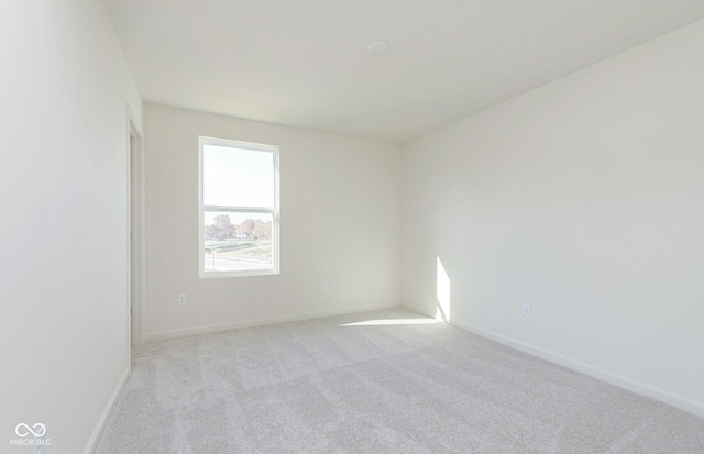 empty room with light colored carpet and baseboards