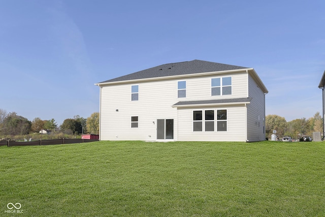 rear view of house featuring a lawn