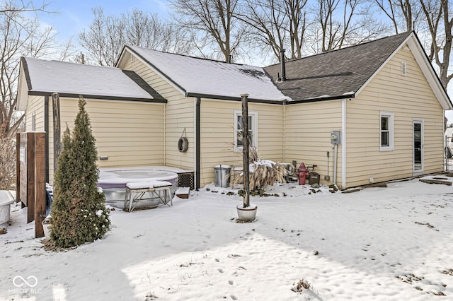 view of snow covered back of property