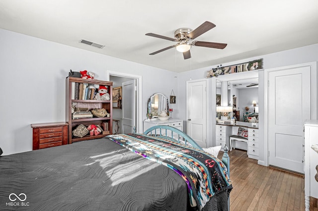 bedroom with a ceiling fan, visible vents, and light wood-style flooring