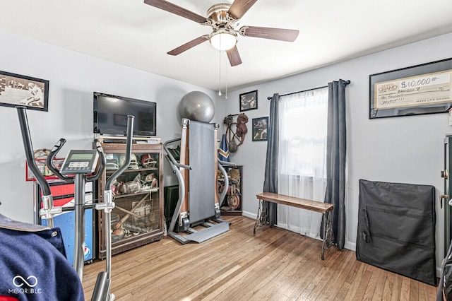 exercise room featuring ceiling fan, baseboards, and wood finished floors