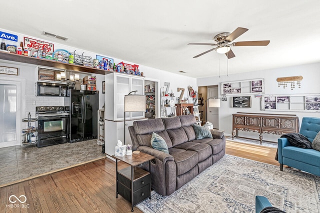 living area with visible vents, ceiling fan, and wood finished floors