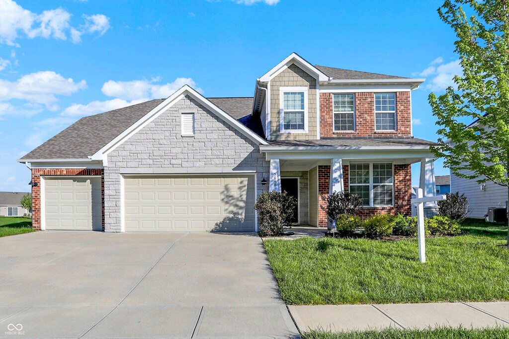 5648 Juniper Ct, Whitestown, IN 46075 - view of front of house with driveway, brick siding, a front lawn, an attached garage, and a shingled roof