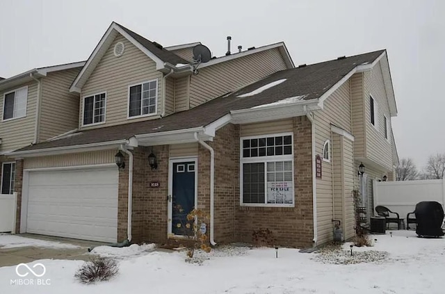 view of front of home with a garage, brick siding, fence, and concrete driveway