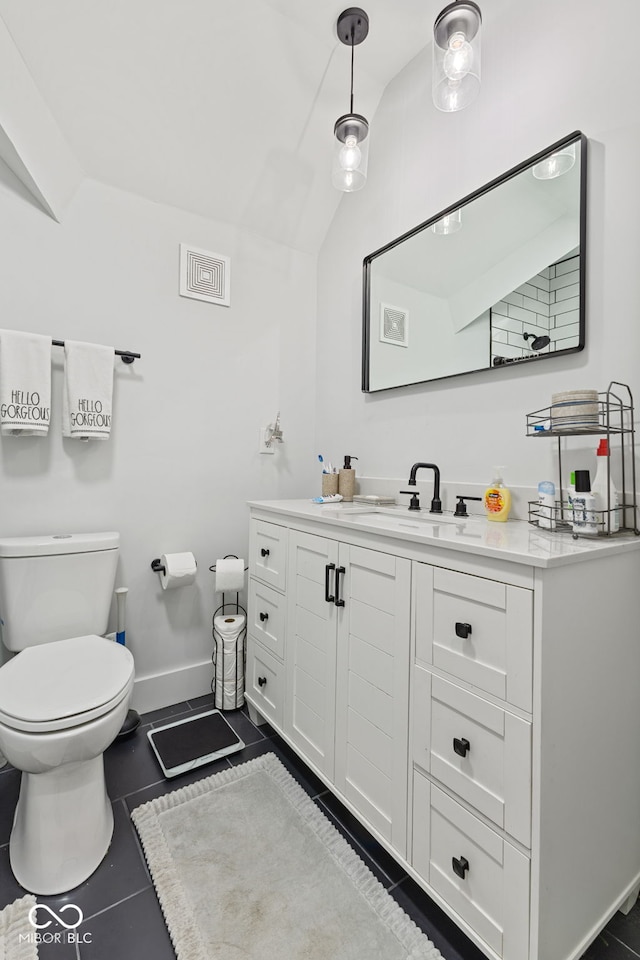 bathroom with tile patterned flooring, toilet, vanity, baseboards, and vaulted ceiling