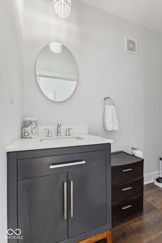 bathroom featuring visible vents, vanity, baseboards, and wood finished floors