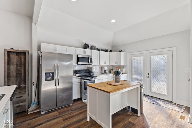 kitchen with wood counters, a center island, stainless steel appliances, french doors, and white cabinetry