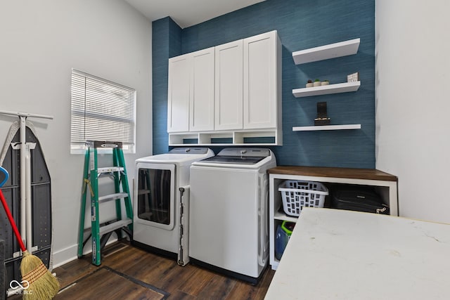 laundry room with cabinet space, dark wood-type flooring, and washing machine and clothes dryer