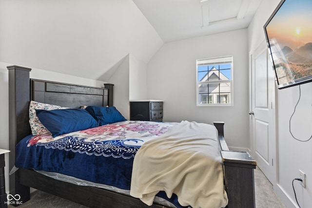 bedroom with attic access, light colored carpet, vaulted ceiling, and baseboards