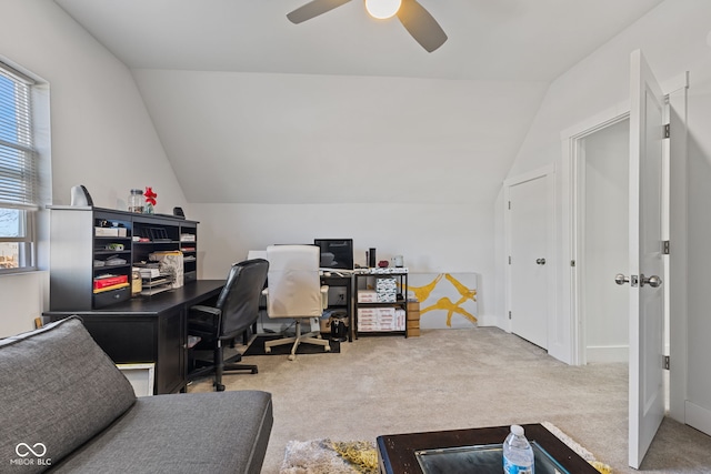 carpeted office with lofted ceiling and a ceiling fan