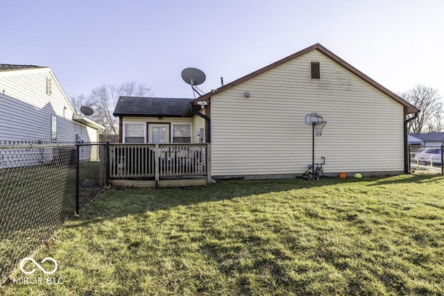 back of property featuring a yard, fence, and a wooden deck