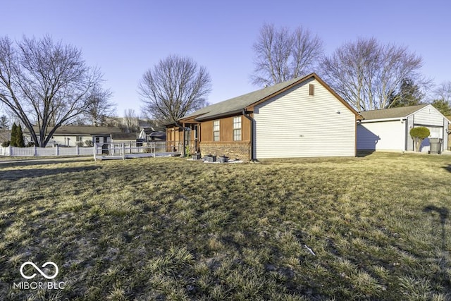 view of property exterior featuring a yard, brick siding, and fence