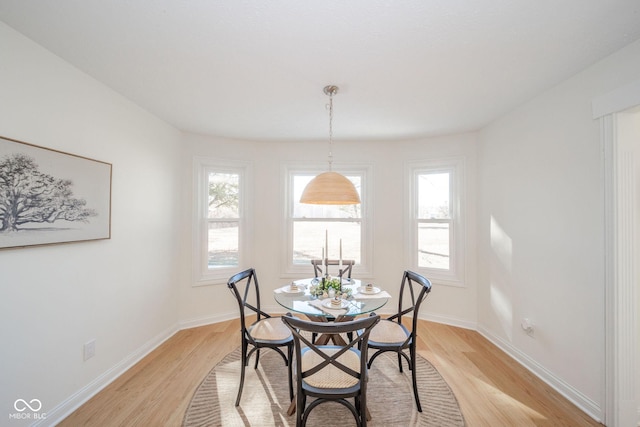 dining area featuring light wood-type flooring, baseboards, and a wealth of natural light