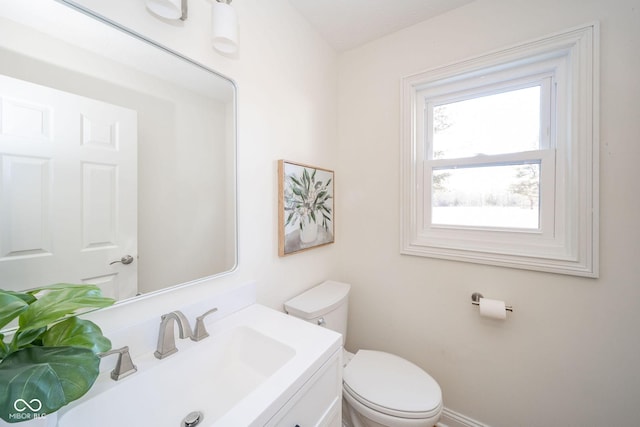 half bathroom featuring vanity and toilet