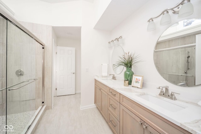 bathroom featuring a stall shower, a sink, baseboards, and double vanity