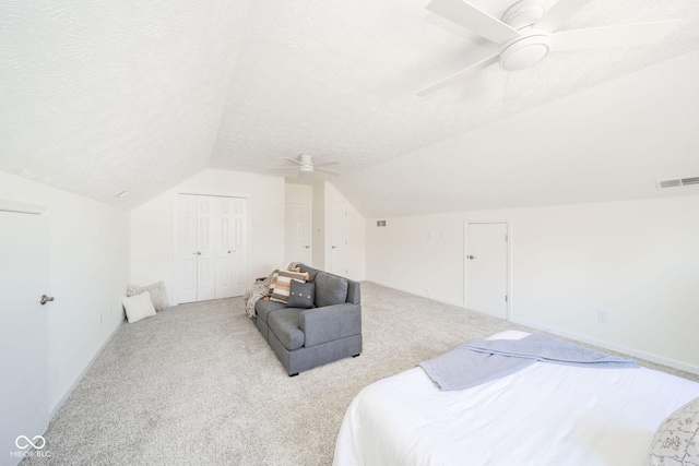 bedroom with visible vents, vaulted ceiling, and a textured ceiling