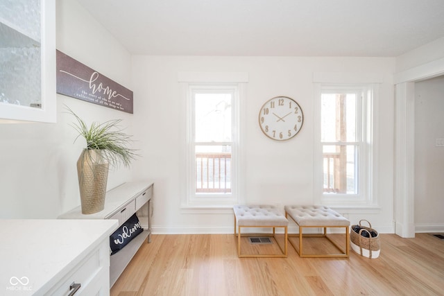 living area with light wood finished floors, baseboards, and visible vents