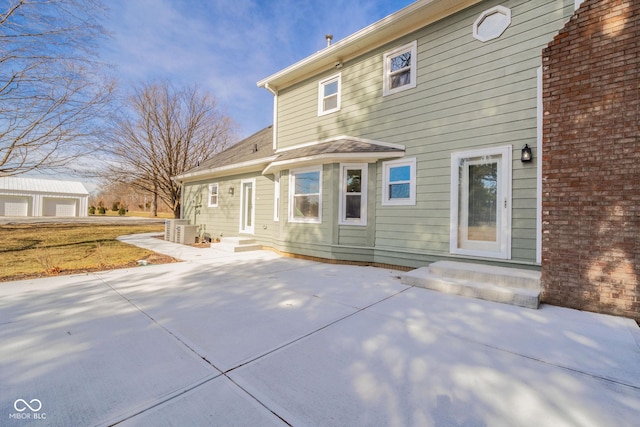 rear view of property featuring central AC and a patio area