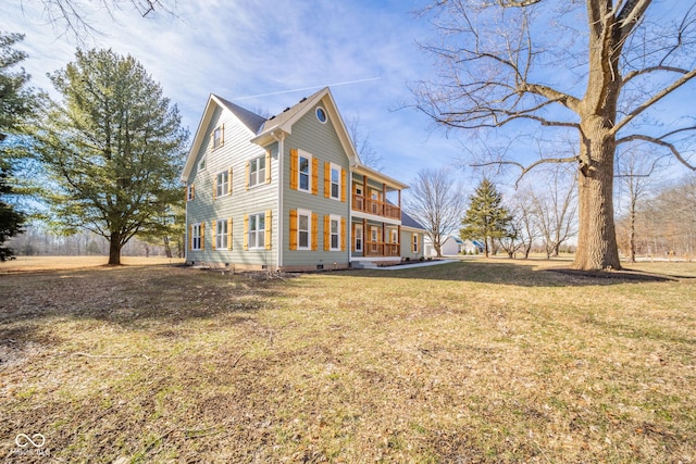 view of side of home with crawl space and a yard