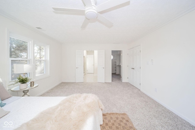 bedroom featuring light colored carpet, crown molding, a textured ceiling, and baseboards